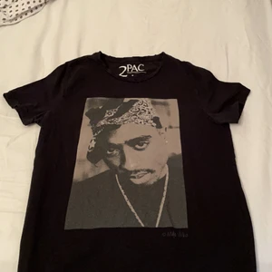 2pac  - Super fin T-shirt, använt ett par gånger men den ser väldigt ny ut! Har nydligen blivit trendig. Har ett fin tryck både i fram och bak samt har den fina detaljer vid armarna. Storlek Xs och funkar galant till S