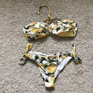Bikini XS/S - Superfin bikini med citronmönster som tyvärr inte kommer till användning hos mig. Inköptes förra sommaren och väldigt lite använd. Toppen är i strl 36 och botten i 34✨🍋  båda delarna har reglerbara knytband så den passar nog flera storlekar. Finns i Lund, skickar även PostNord spårbart.