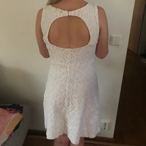 Vit klänning  - Jag säljer en vit spetsklänning från Vila. Den har en öppen rygg med knappar och en dragkedja på ena sidan. Längden är ca 80cm. I befintligt skick. Kontakta mig i dm om du är intresserad😊🌸