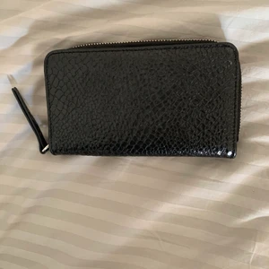 Plånbok från Monki - Gullig plånbok från Monki i svart fake skinn. Den är ganska rymlig och du får plats med både kort, kontanter och kvitton. Kostade 200kr ny.😌