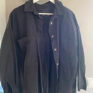 Svart oversized skjortjacka - Svart skjortjacka i herrmodell, sparsamt använd och fint skick. Snyggt oversized på mig som är en 36/38.