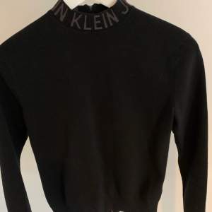 Svart polotröja från Calvin Klein med dragkedja i ryggen och logga på kragen. Skönt och stretchigt material. Använd bara  ett fåtal gånger så den är i bra skick (det är spegeln som är fläckig på bilden och inte tröjan). Strl XS💜