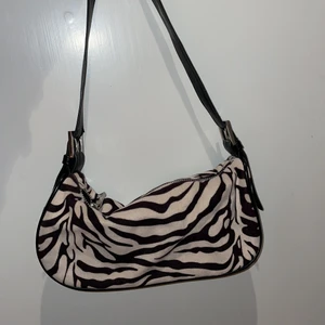 zebra väska - säljer denna superfina zebra mönstrade axelväska från gina tricot🤍 väl använd men ändå fint skick och har tvättats. säljer för att den inte längre kommer till användning!🤍 köptes för 300kr och säljs för 160kr+frakt fast pris kan diskuteras!🤍