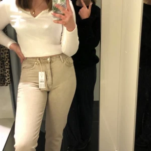 Jeans - Beige mom jeans från Gina tricot, färgen gör sig ej rättvis genom kamera men det är en klar beige färg. Storlek 38 men passar också som en 36. Jättebra skick. Nypris 500 kr.