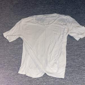 En vit t-shirt i storlek 146-154 men VÄLDIGT stor i storleken, har en liten detalj längst ner där tyget lägger sej omlott på varandra 