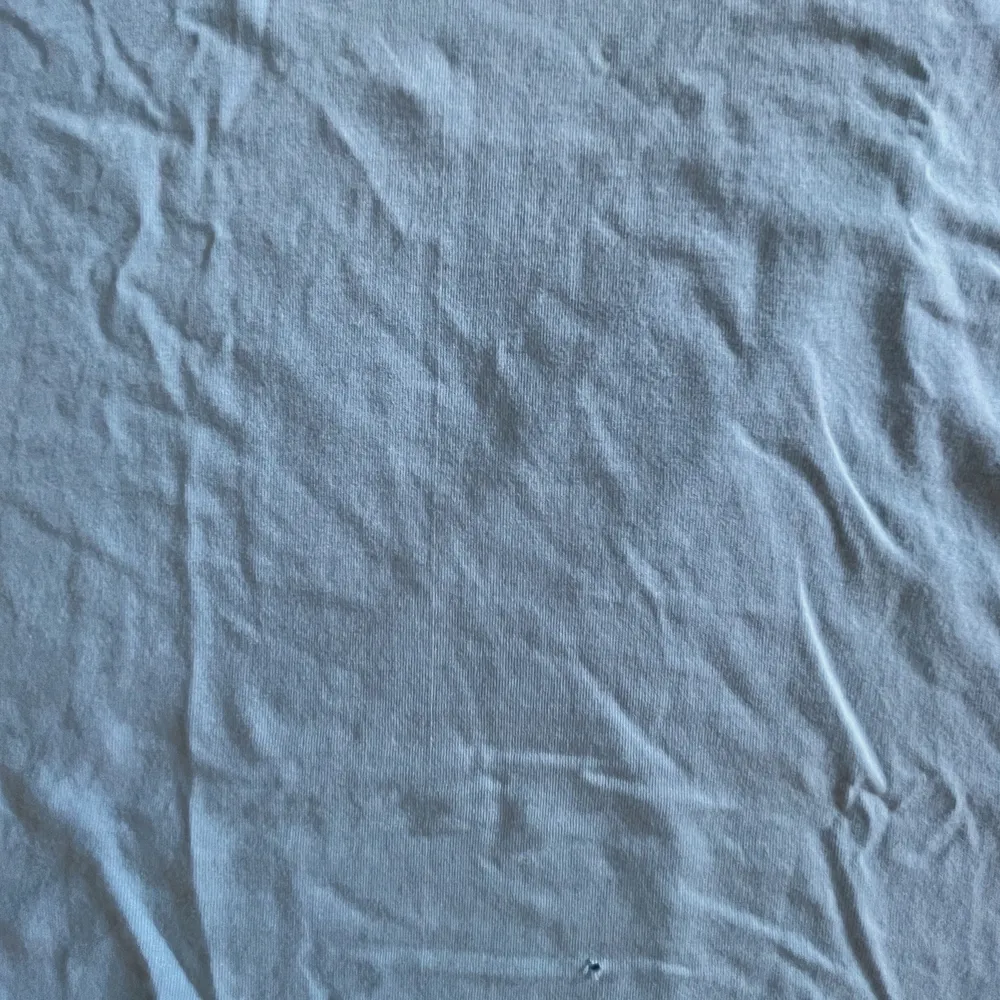 En ljusblå v ringad T-shirt från Adidas. Den har ett jättelitet hål längst ner på tröjan som knappt syns. Vintage!. T-shirts.