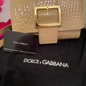 Liten och nätt Dolce & Gabbanaväska med leopard innerfoder. Fack med blixtlås och magnetstängning. Bredd: 18 cm Djup: 3 cm Höjd: 11 cm 