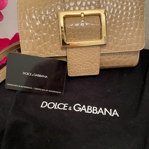 Crossbody Dolce & Gabbana väska  - Liten och nätt Dolce & Gabbanaväska med leopard innerfoder. Fack med blixtlås och magnetstängning. Bredd: 18 cm Djup: 3 cm Höjd: 11 cm 