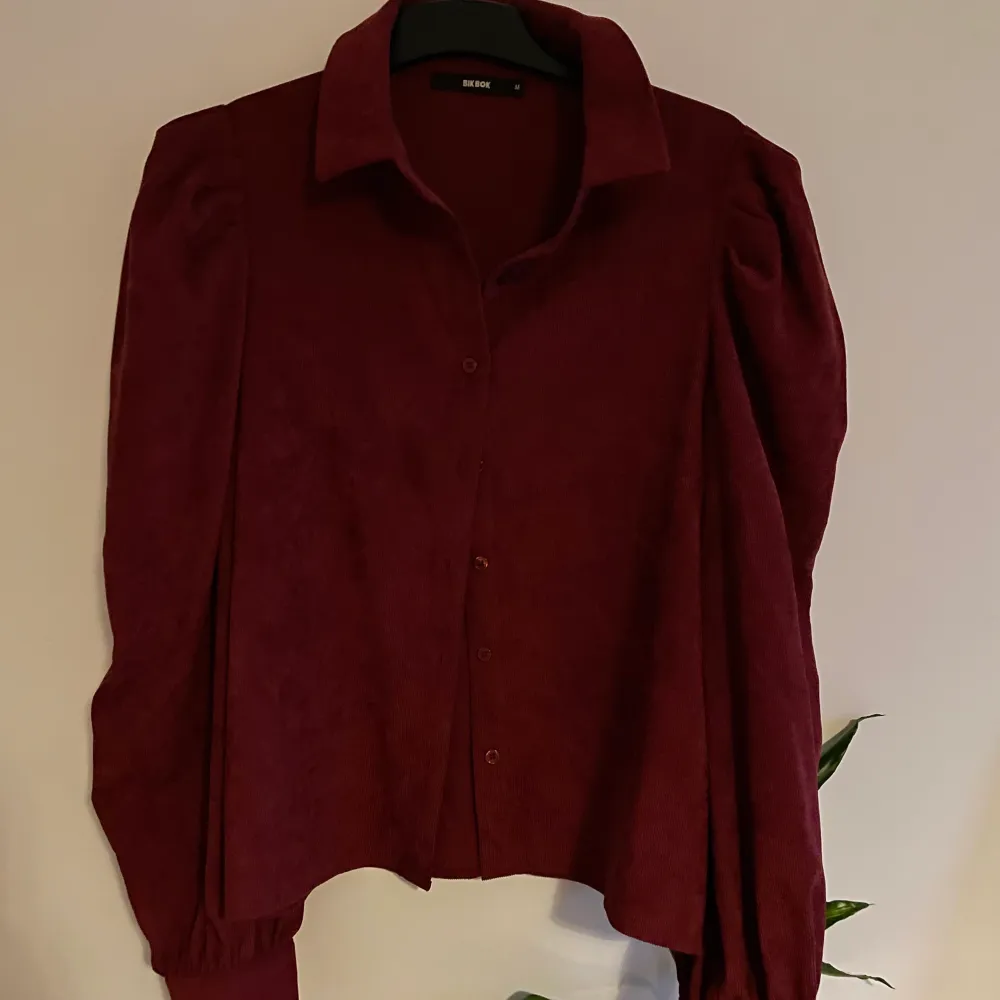 Säljer denna jättefina vinröda manchester skjorta med puffiga axlar från BikBok, i princip oanvänd! Fraktar eller möts upp i Kalmar 🥰. Skjortor.