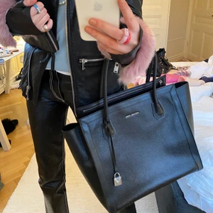 Michael Kors väska - Säljer min älskade ÄKTA Michael Kors väska då den tyvärr inte kommer till användning längre. Väskan är i nyskick och har varken fläckar eller slitningar! Den får plats med mycket och har många funktionella fack. Passar perfekt som till exempel skolväska! I svart läder med silverdetaljer. Väskan är äkta såklart och kommer med en stor dustbag till. Skriv för fler bilder! Nypris: 3100kr❤️❤️❤️❤️❤️