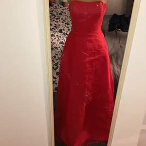 Balklänning i röd färg med pärl detaljer, aldrig använd storlek xs