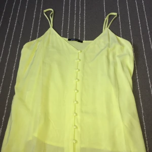Neon grön/gult linne - Köpt från Ginatricot, storlek 36, väldigt fin och somrig. Jätteskönt kvalitet och mjukt, färgen är magisk i solen och passformen är bra!!