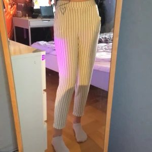 Vita kostymbyxor Hm - Säljer dessa svart/vit randiga kostybyxor från hm då jag helt enkelt växt ur dom. Storlek XS. Dom har resår i midjan och är vikta vid anklarna. Har fickor fram på vardera sida. Använda endast ett fåtal gånger. Köparen står för frakten💕