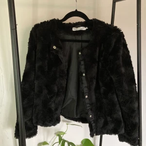 Svart jacka i fuskpäls - Mysig och fin jacka i fuskpäls, perfekt nu till våren! Tror att den är köpt från VeroModa, men märket är dust. Köparen står för frakten. Hör gärna av dig om du undrar över något!🖤🖤🖤