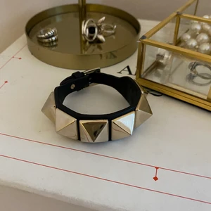 Valentinoarmband  - Armband från valentino i svart läder med guldiga nitar, har fått sy ihop en del, men detta är knappt märkbart (se bild 3). Säljs då det inte längre kommer till använding