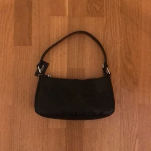 Axelbandsväska - Säljer en svart axelbandsväska, mönstret är fake ormskinn! Aldrig använt! Köparen betalar frakten 