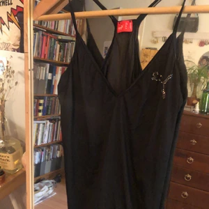 Puma rhinstone topp - Så snyggt linne med rhinestone detalj från puma! Den är i ett tunt tränings material men skulle se SÅÅÅ snygg ut med ett par jeans!!!!! Aldrig använd utav mig men köpt second hand!