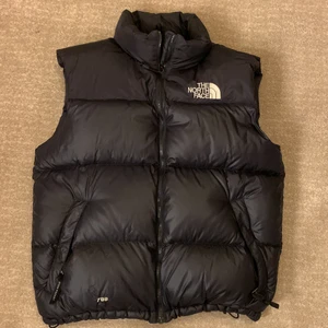 The north face dunväst stl L - Fin kvalitetsväst, den är i storlek large.  Med en inbyggd luva i kragen. Ordinarie pris 2500. Frakt 99kr