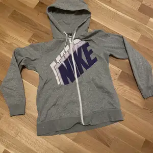 En Nike huvtröja/ ziphoodie i färgen grå:) 