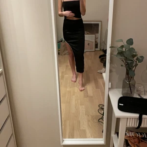 Kjol med slit - Svart kjol i silke med slit och snygg detalj. Aldrig använd, endast testad.