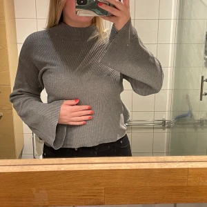 Grå stickad tröja med korsad rygg - Grå stickad tröja men korsad rygg. Fint skick, använd en del. Tvättas innan leverans!