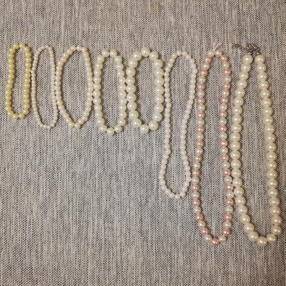 Det första armbandet: små pärlor, lite mer gulaktigt, 18 cm. Det andra: Såld. Det tredje: vitt, små pärlor, 19 cm. Det fjärde: vitt, mellanstora pärlor, 19 cm. Det femte: vitt, stora pärlor, 19 cm. Det första halsbandet: vitt, små pärlor. Accessoarer.