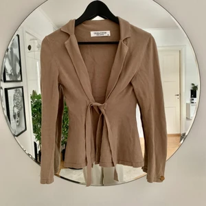 Beige kofta  - Beige kofta, går knytas fram eller bak 