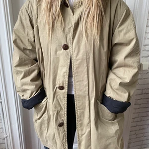 Jacka   - Beige kappa från hugo boss, köpt second hand. Modellen har vanligtvis S/M och jackan är något oversized på henne. 