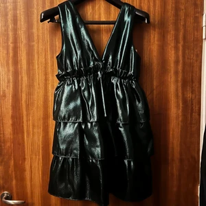 Grön Zara klänning - Säljer denna superfina oanvända klänning från Zara. Den är mörkgrön och glansig, perfekt till fest. Den är i storlek medium och passar mig som har M bra, men den har tyvärr aldrig kommit till användning. 