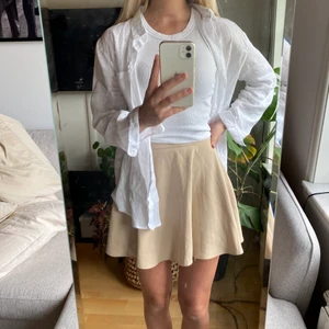 BIEGE KJOL - Biege kjol i skönt, fallande material. Försluts med liten dragkedja baktill. 