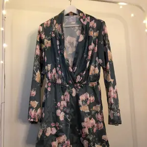 En grön blommig jumpsuit ifrån NA-KD i jätte fint skick andvänd ett få tal gånger i stl 38 det finns ett skärp till som man kan knyta åt i midjan men man kan ta bort det om man vill 