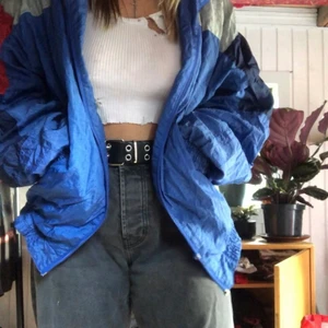 Vintage vindjacka - Vintage blå vindjacka med röda detaljer på armarna och vitt tryck på ryggen. Den är varm men ändå sval. Perfekt för sommaren och hösten🌹