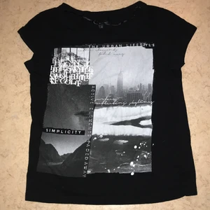 Svart T-shirt med tryck och text  - Svart T-shirt med tryck och text i svartvitt och gråskala. Bra skick, nästan oanvänd. 