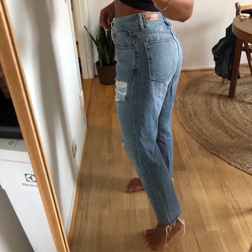 Blå jeans med slitningar från BikBok. Avklippta efter min längd, jag är 164cm. Storlek M. Fint skick.. Jeans & Byxor.