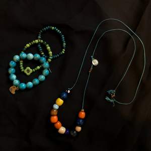 långt halsband med pärlor i olika färger, och tre matchande armband med berlocker. säljs i set!💙