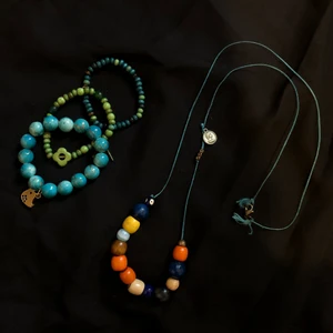 smycken - långt halsband med pärlor i olika färger, och tre matchande armband med berlocker. säljs i set!💙