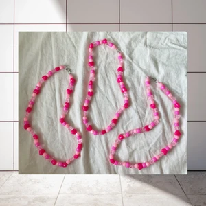 Rosa pärlhalsband 💞 - Halsband med pärlor i plast. Snöret är av resår och knäpps med hyska. Det finns tre likadana halsband, alla med hjärtan och transparenta blommor. Det finns likadana halsband i blå och lila på min profil! 30kr/st, 15kr frakt. Jag ansvarar inte för postens slarv.