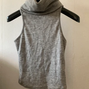 Topp/linne - En grå stickad topp/linne med hög krage
