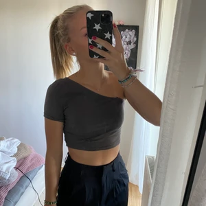 one shoulder topp - grå one shoulder topp som passar till fest som vardag! Endast använd en gång! 65kr+frakt