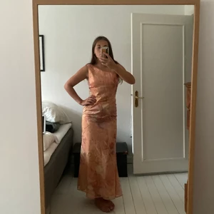 Drömklänningen i pastell - Jättefin oneshoulder klänning för fina festligheter! Otroligt fin blandning av färger och väldigt skön att ha på sig. Jag är 168 och mina fötter syns, perfekt för att visa upp klackarna! Den har dragkedja på ryggen och en underklänning. 