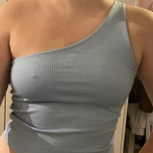 Baby Blått Linne - Kort blått linne med ett band från Ginatricot. Som nytt. Storlek: S. Lappen är bortklippt. Köparen står för frakt. 50kr + 45kr