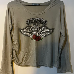 Beige tröja med ballt tryck - Beige, långärmad tröja med ballt tryck. Det finns en ”volang” detalj på slutet av ena sidan av tröjan vilket går att se på bild 3. På storleken står det bara 13/14 men skulle säga att den passar allt från XS till M. 