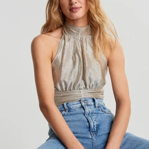 Snygg topp! - Snygg och trendig glittertopp med öppen rygg från ginatricot! Storlek small. Endast använd en gång så är gott som ny! Helt slutsåld och köptes för 300 och sätter ett pris på 100 kr! Första bilden är lånad!