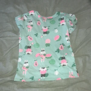 T-Shirt  - En turkos färgad t-Shirt med frukter och djur på. Använda några gånger