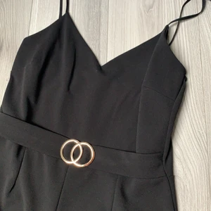 Byxdress - En byxdress i storlek XL med smala axelband, visa ben och ett ”skärp” som ska vara en detalj, 