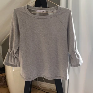 Grå tröja - Grå trjöja med volang armar, modellen är kortare i armen. Storlek S väldigt fin säljer på grund av att det inte är min stil. Använd men bra skick