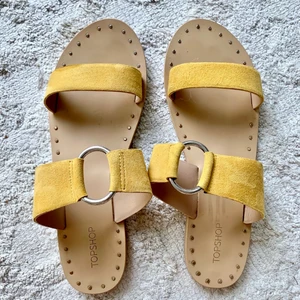 Sandaler/ stl: 40/ slip-ins/ fint skick  - Sandaler från Topshop, endast använda två gånger. Säljes då jag har för många skor! Storlek 40, normal i storleken. Sandalerna är i mocka och har en fin gul färg. Runt om sulorna finns platta nitar (de känns inte när man har skorna på sig).