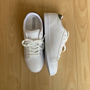 NLY sneakers, strl 40 - Helt oanvända skor från Nelly i storlek 40. Vita med mörk grön detalj på baksidan. Skickas i originalkartong. Frakt tillkommer. 