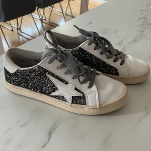 Le Temps Des Cerises skor glittriga  - Glittriga skor från Le Temps. Använda fåtal gånger. I fint skick. Det enda som går att anmärka på är en viss slitning på sidan där glittret skavts bort lite (se sista bilden). OBS! Den beiga färgen på skosulan är inte smuts utan den ska vara lite mer äggskalsvit. Skorna är i storlek 37 men passar mig som vanligtvis även kan ha strl 38 på i övrigt. Köptes för 600kr på Zalando. 