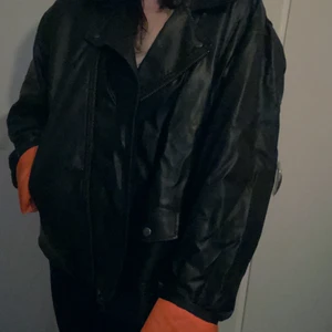 Oversize fakeläderjacka för plus size - Riktigt stor och pösig skinnjacka i fake läder från Collusion. Storlek 2XL. Jag som vanligtvis är en storlek L bokstavligen drunknar i den, men sitter säkert perfekt på dig som är en eller två storlekar större eller bara längre.(Jag är 170 för referens). Använd men i fint skick, lite skrynklig av att ha legat nerpackad. Medföljer även en kedja som ska sitta fast i fickan, men jag valde att ta av den. 